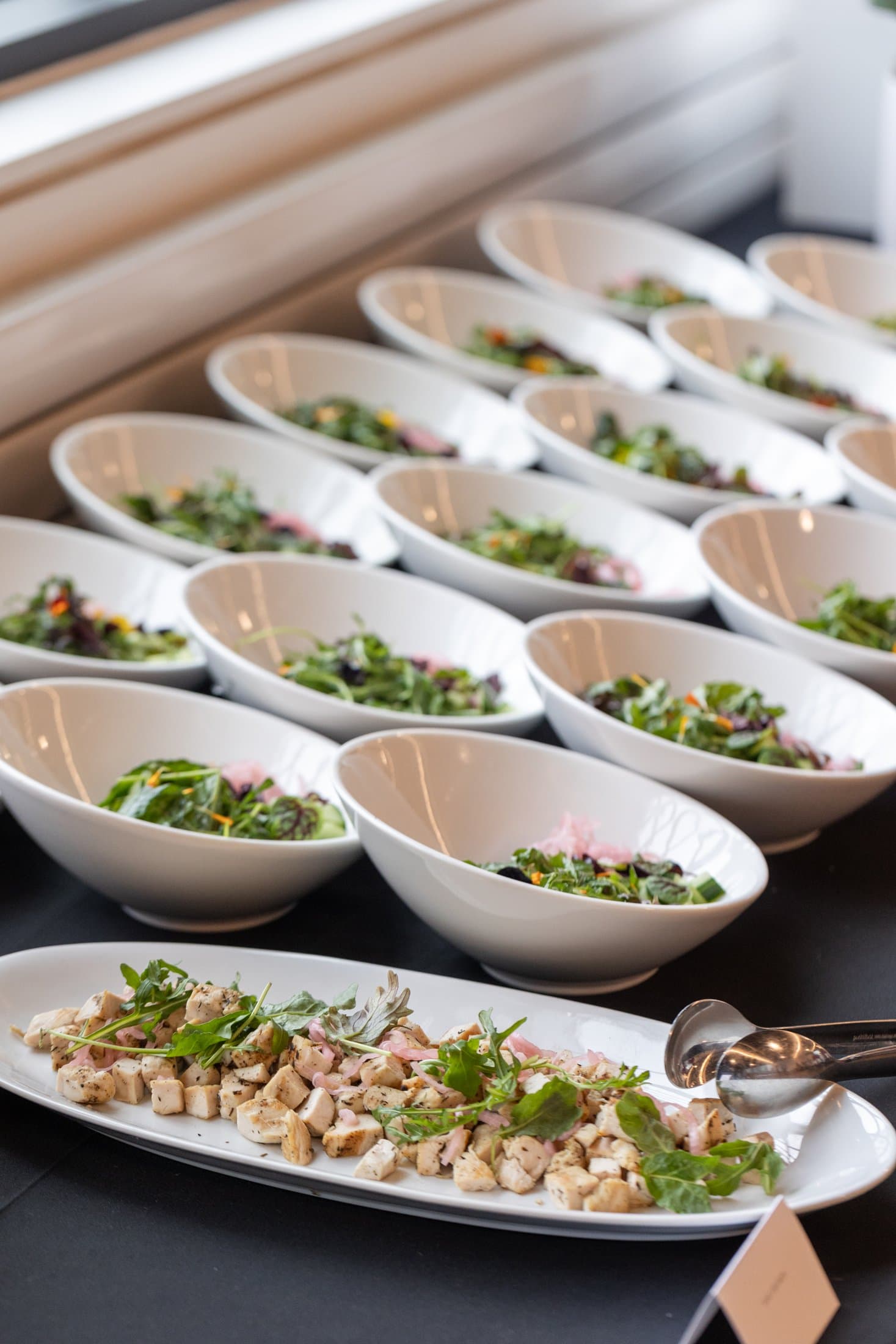 Buffet catering — rows of salad bowls and a shared serving platter